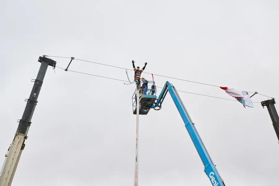 Doug Hunt with arms to the sky on stilts after successful attempt