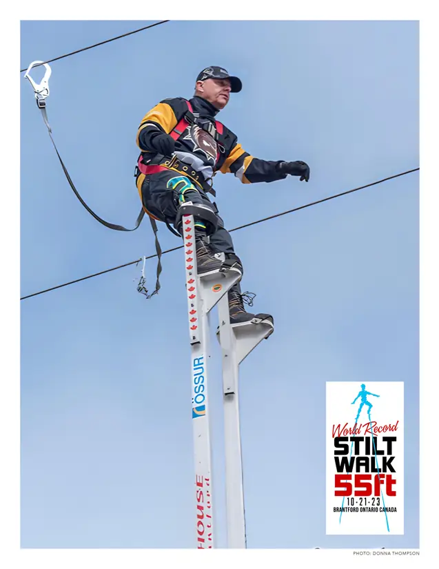 Doug Hunt on Stilts outside with Stilt Walking logo